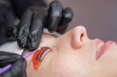 Beyaz kadın kirpik temizleme prosedüründen geçiyor.