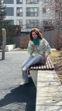 Beyaz kadın yürüyor ve akıllı telefon kullanıyor.