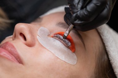 Beyaz kadın kirpik temizleme prosedüründen geçiyor.