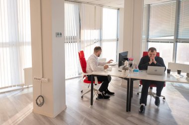 Bir ofiste çalışan iki beyaz adam.