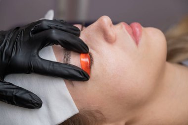 Beyaz kadın kirpik temizleme prosedüründen geçiyor.