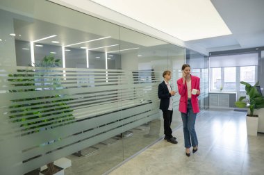 Meslektaşlar iş aralarında akıllı telefon kullanırlar