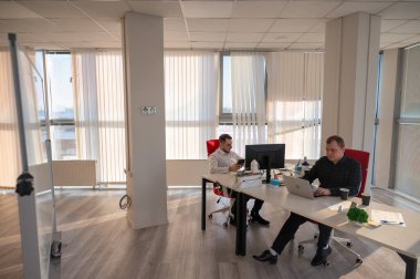 Bir ofiste çalışan iki beyaz adam.