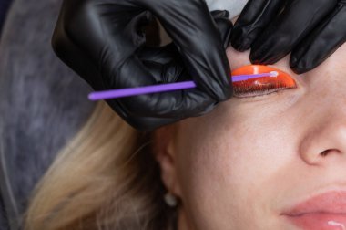 Beyaz kadın kirpik temizleme prosedüründen geçiyor.