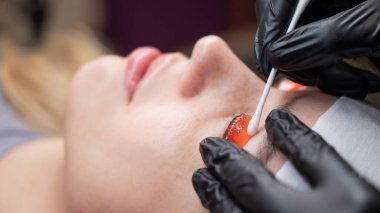 Beyaz kadın kirpik temizleme prosedüründen geçiyor.