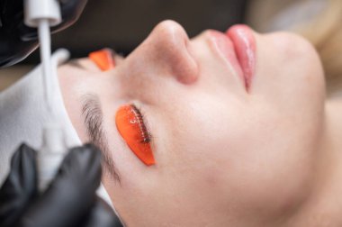 Beyaz kadın kirpik temizleme prosedüründen geçiyor.