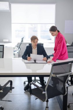 Beyaz kadın astlarına talimat veriyor.