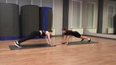 İki beyaz kadın dinamik bir kalas yapıyor.