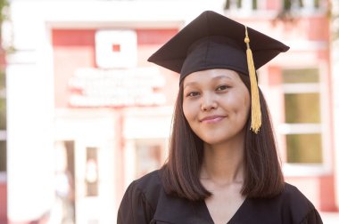 Mezuniyet elbisesi içindeki mutlu Asyalı kadın.