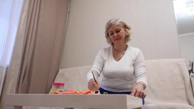 Olgun kadın çocuk plastiklerinden heykel yapıyor.