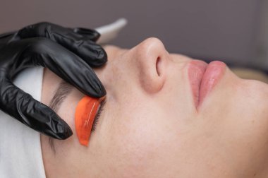 Beyaz kadın kirpik temizleme prosedüründen geçiyor.