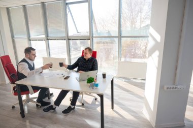 İş arkadaşları ofiste kahve içiyor.