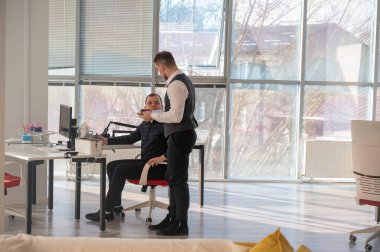 Bir ofiste sohbet eden iki beyaz adam.