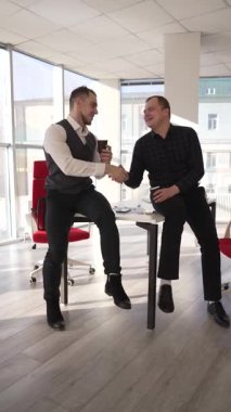 İş arkadaşları ofiste kahve içiyor.