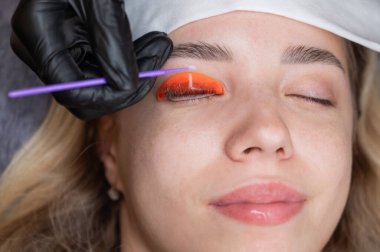 Beyaz kadın kirpik temizleme prosedüründen geçiyor.