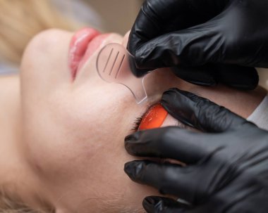 Beyaz kadın kirpik temizleme prosedüründen geçiyor.