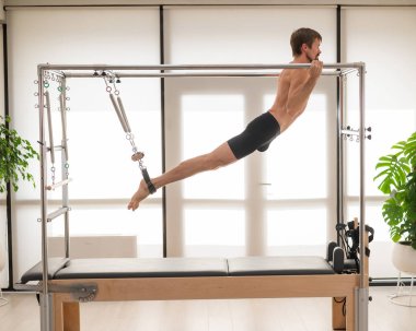 Bir adam yenilikçi bir makine üzerinde hava tatbikatları yapıyor.