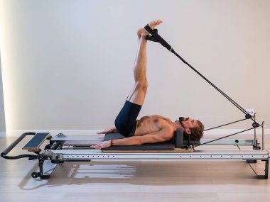 Reformcu üzerinde pilates yapan bir adam.