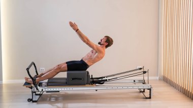 Reformcu üzerinde pilates yapan bir adam.