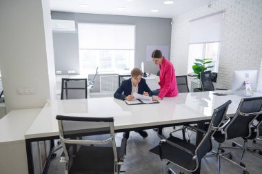 Beyaz kadın astlarına talimat veriyor.