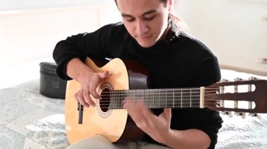 Genç adam akustik gitar çalıyor. Parmak Biçimi