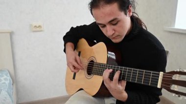 Genç adam akustik gitar çalıyor. Parmak Biçimi