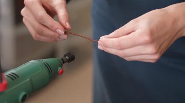 Bir bronzlaştırıcı atölyede deri kemerin kenarlarını inceler. Kadınların ellerinin yakın çekimi.