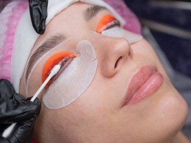 Beyaz kadın kirpik temizleme prosedüründen geçiyor.