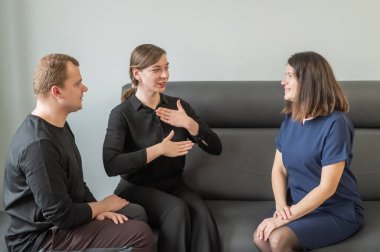 Bir adam ve iki kadın Rusça işaret diliyle konuşuyorlar.