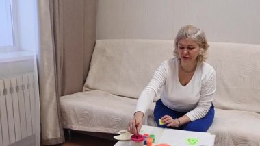 Olgun kadın çocuk plastiklerinden heykel yapıyor.