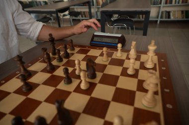 Bir adam satranç saatini değiştirir.