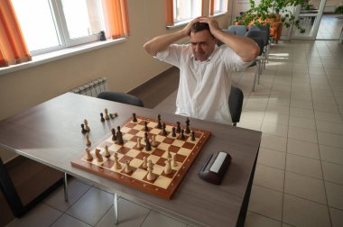 Beyaz adam satranç oyununu kaybettiği için üzgün.