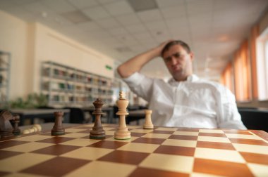 Orta yaşlı beyaz adam satranç oynuyor.