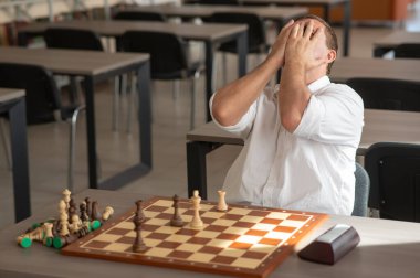 Orta yaşlı beyaz adam satranç oynuyor.