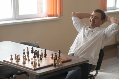 Beyaz adam satranç hamlesi düşünüyor.