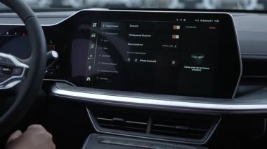Bir adam modern bir arabada dokunmatik ekran kullanır.