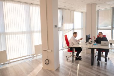 Bir ofiste çalışan iki beyaz adam.