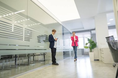 Meslektaşlar iş aralarında akıllı telefon kullanırlar