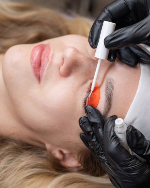 Beyaz kadın kirpik temizleme prosedüründen geçiyor.