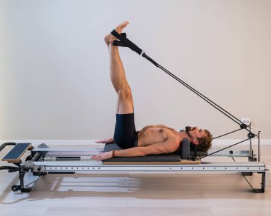 Reformcu üzerinde pilates yapan bir adam.