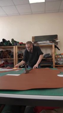 Beyaz sakallı adam bir atölyede bronzlaştırıcı olarak çalışıyor.