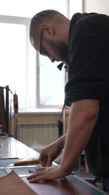 Beyaz sakallı adam bir atölyede bronzlaştırıcı olarak çalışıyor.