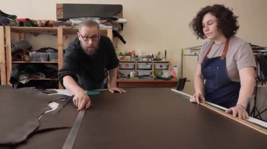 Bir erkek ve bir kadın bir atölyede tabakçı olarak çalışıyorlar.