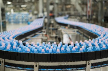 Fabrikadaki taşıma bandında şişe su.