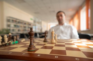 Orta yaşlı beyaz adam satranç oynuyor.