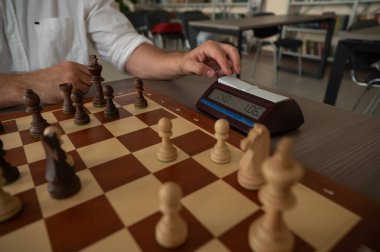 Bir adam satranç saatini değiştirir.