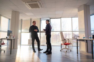 Ofiste konuşan iki beyaz adam.