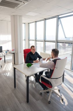 İki beyaz adam bir iş toplantısında iletişim kuruyor.