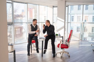 İş arkadaşları ofiste kahve içiyor.