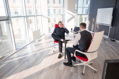 Bir ofiste pazarlık yapan iki beyaz adam.